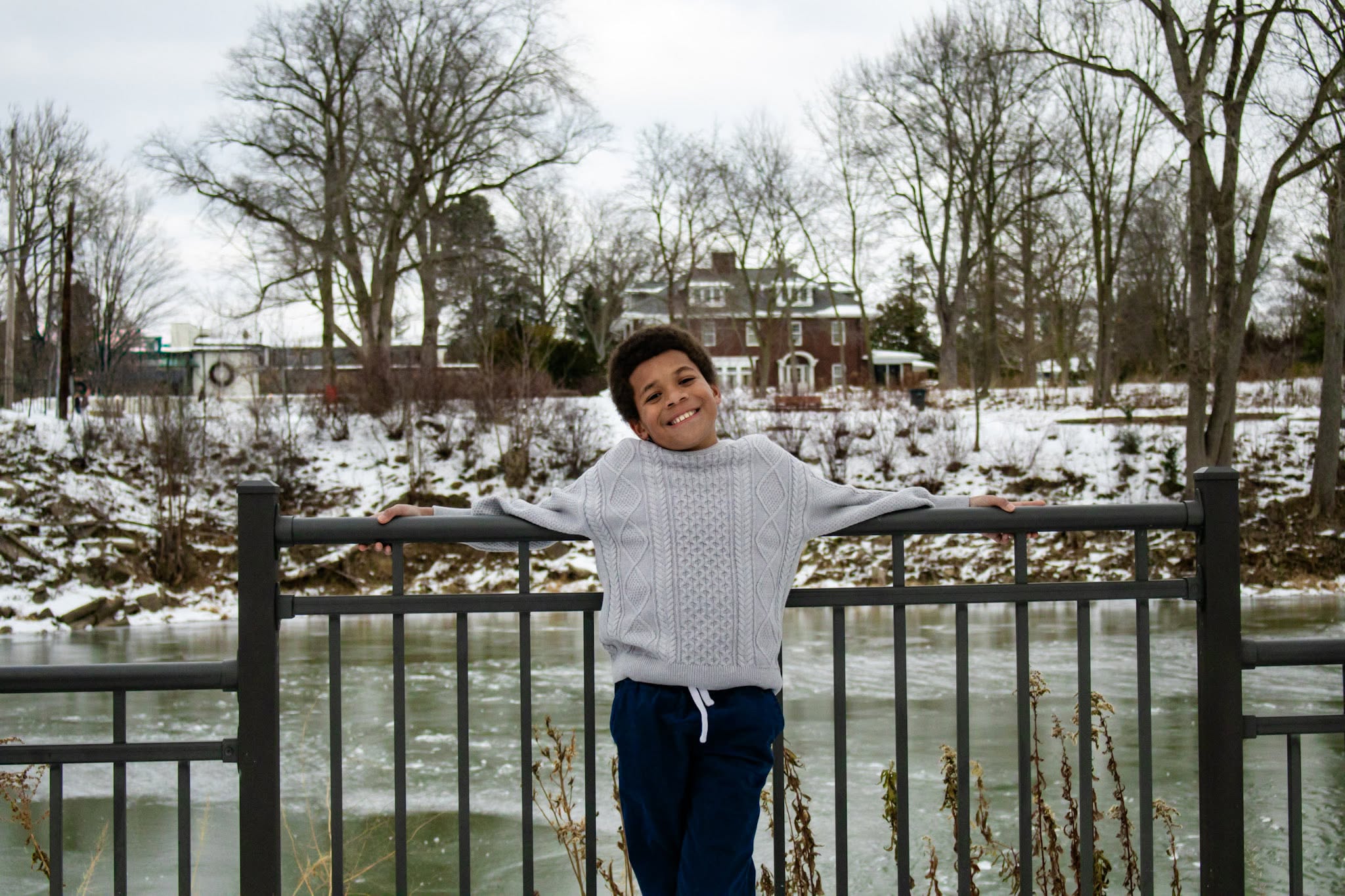 Boy smiling by the water in winter